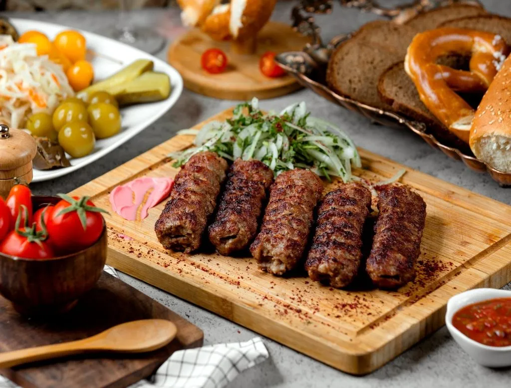 Reich gedeckter Tisch mit Balkan-Grillspezialitäten und Beilagen
